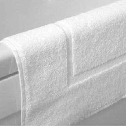 White cotton bath mat placed on hotel bathroom floor – INEQUIP
