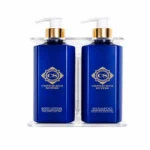 Wall-mounted bathroom liquid dispenser set with shampoo, body lotion, and hand wash bottles in a modern holder on a clean background